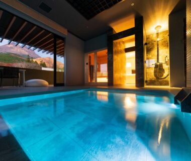 Indoor bathing area with luminous pool, sliding doors and wooden accents at Gekkoju Yufuin, Ōita