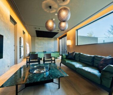 Spacious lounge with green marble coffee table, sofas, pendant lamps and large window at Gekkoju Yufuin in Ōita, Kyūshū