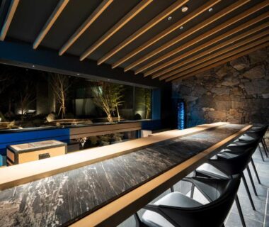 Long marble counter with stools and wooden slatted ceiling at Gekkoju Yufuin Ōita