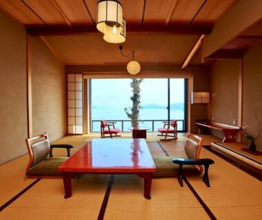 Traditional tatami room with low table, floor cushions, shoji doors opening to a serene water view at Genmyoan Kyoto