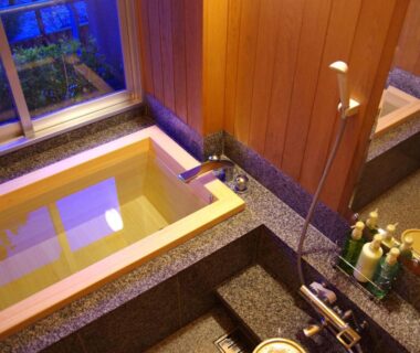 Wood-framed soaking tub and shower beside window at Gero Onsen Yukyunohana, Gifu, Chubu
