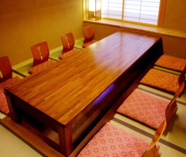 Low wooden dining table with zabuton cushions in tatami room at Gero Onsen Yukyunohana, Gifu