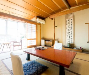Traditional tatami room with low table, zabuton cushions and shoji screens at Gingetsu in Nagano