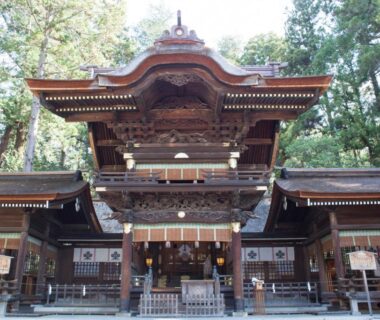 Traditional wooden shrine with carved eaves and tall cedar trees at Gingetsu, Nagano, Chūbu
