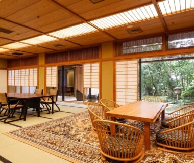 Tatami room with shoji screens, low tables and rattan chairs at Ginsuisou Choraku Hyōgo