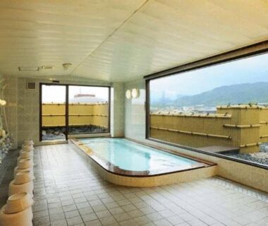Tiled indoor onsen with soaking tub and shower stations at Gion Fukuzumi, Kyoto city and mountain view