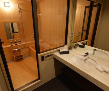 Wooden soaking tub and vanity separated by glass at Gion Oyado Kikutani, Kyoto