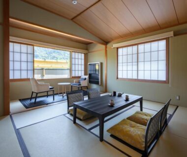 Bright tatami room with low table, zabuton cushions, shoji screens and window seating at Gion Ryokan Karaku Kyoto