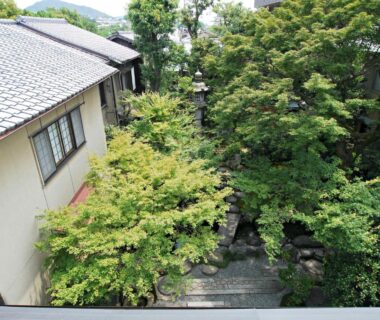 Leafy courtyard with stone steps between buildings at Gion Ryokan Q-beh, Kyoto Kansai