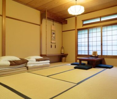 Tatami room with folded futon, low table and shoji screens at Gion Ryokan Q-beh Kyoto