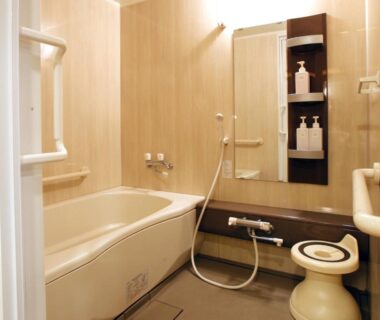 Compact Japanese-style bathroom with bathtub, hand shower, stool and toiletries at Gion Shinmonso Kyoto