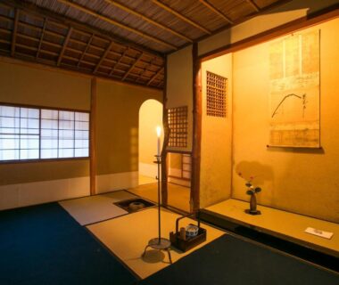 Traditional tatami room with tokonoma alcove, hanging scroll, shoji window and warm lighting at Gion Yoshiima Kyoto