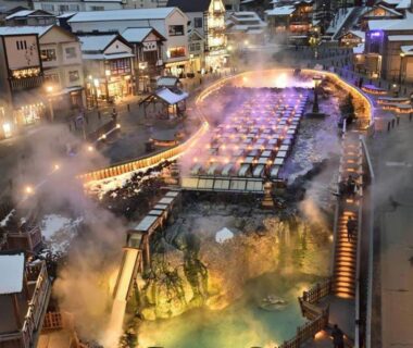 Steaming onsen channel with wooden walkways by Goroji Bekkan in Gunma town