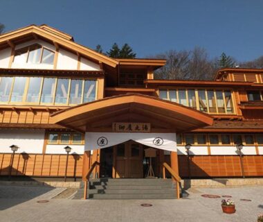 Entrance and wooden facade of Goroji Bekkan with noren and surrounding trees in Gunma, Kantō