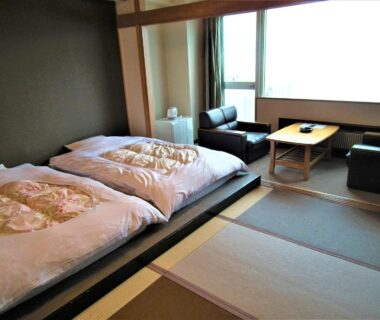 Tatami room with two futons, low table and seating area at Granvillage Toya Daiwa Ryokan Annex Hokkaidō