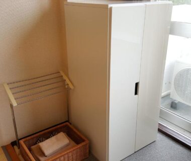 Tatami flooring with small wardrobe, towel basket and sliding balcony door with outdoor AC unit