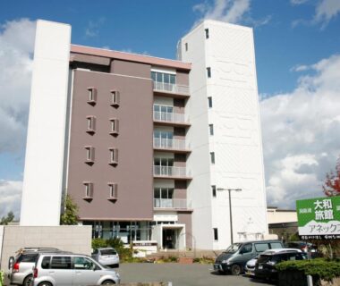 Multi-story ryokan exterior with parked cars and entrance sign at Granvillage Toya Daiwa Ryokan Annex in Hokkaidō