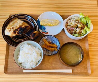 Grilled fish, rice, miso soup, tamagoyaki and salad on tray at Guest House Nemuroman Hokkaido
