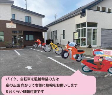 Parking lot with colorful children's ride-on bikes outside Guest House Nemuroman in Hokkaido