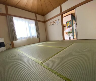 Traditional tatami room with sliding fusuma doors, wood ceiling and window at Guest House Nemuroman in Hokkaido