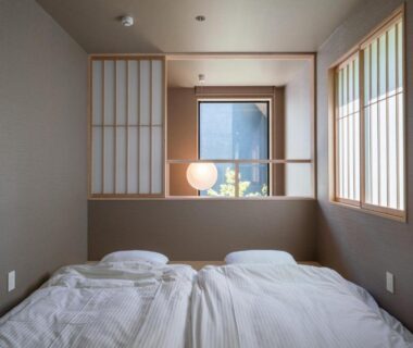 Low futon bedding with shoji screens and window lamp at Gunjo no Tsuki in Ishikawa, Chūbu