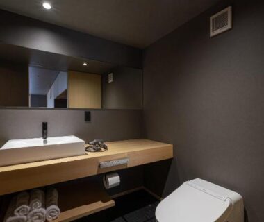 Minimalist bathroom with sink, wooden vanity, mirror and modern toilet at Gunjo no Tsuki, Ishikawa