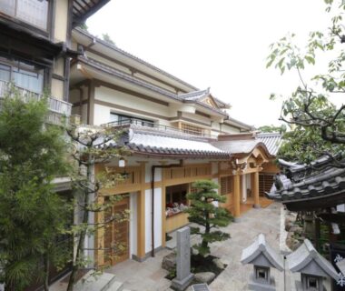 Exterior courtyard of Gyokuzoin with tiled roofs, wooden eaves, stone lanterns and garden elements in Nara