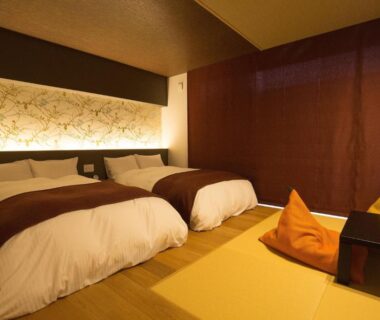 Tatami room with twin beds, low table and cushions at HOSHINO-OTOー星音 in Kyoto, Kansai, Japan