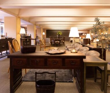 Spacious ryokan lounge with wooden tables, sofas and warm lamps at HOTEL SHIRAHAMAKAN in Wakayama