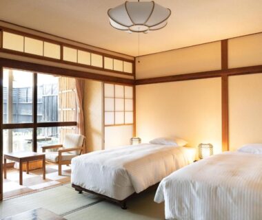Tatami room with twin Western beds, shoji screens and low table at HOTEL SHIRAHAMAKAN in Wakayama
