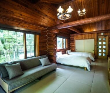 Log interior tatami room with twin beds, sofa and forest view at Hacho no Yu, Tochigi
