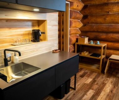Compact kitchenette with sink, kettle and shelving in a wood-paneled ryokan room at Hacho no Yu, Tochigi