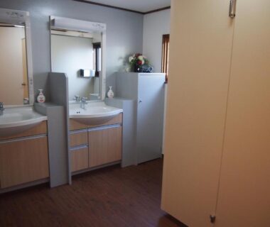 Shared wash area with two sinks, mirrors and small refrigerator at Hagurokan in Yamagata Tōhoku
