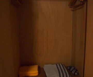 Wooden wardrobe with hangers and folded linens in a ryokan room at Hagurokan, Yamagata, Tōhoku, Japan