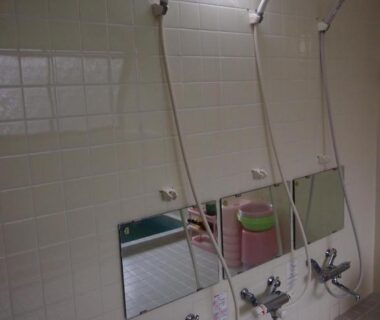 Three tiled shower stations with low mirrors and buckets at Hagurokan in Yamagata, Tohoku