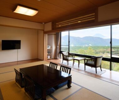 Tatami room with low dining table and balcony seating overlooking mountains in Hakone, Kanagawa