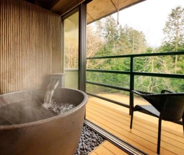 Steaming wooden soaking tub on balcony with chair, forest view at Hakone Fuga, Kanagawa