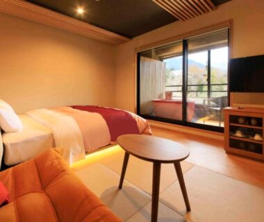 Tatami room with low table, bed and balcony at Hakone Fuga in Kanagawa