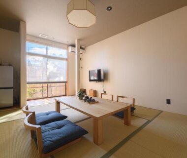 Bright tatami room with low wooden table, floor cushions, television and large window at Hakone Gora Ten Kanagawa