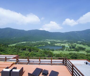 Wooden terrace with lounge chairs overlooking a verdant valley and hills at Hakone Hoshi no Akari, Kanagawa
