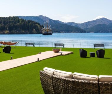 Wicker lounge seating and lawn terrace overlooking lake and mountains at Hakone Hotel, Kanagawa, Japan