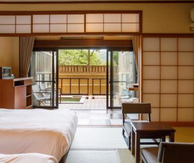 Tatami room with beds, shoji screens and sliding doors opening to a small balcony