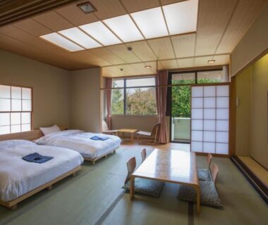 Tatami room with two low futon beds, shoji screens, low wooden table and garden view at Hakone Kowakien Miyamafurin, Kanagawa