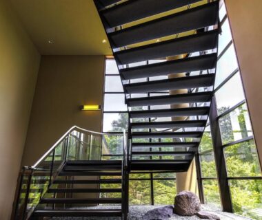 Interior metal staircase with large windows and garden view at Hakone Kowakien Miyamafurin in Kanagawa, Japan