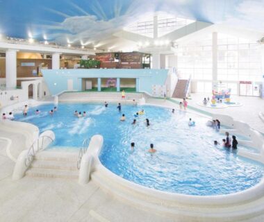 Large indoor recreational pool with families, shallow wading areas and play features at Hakone Kowakien Miyamafurin, Kanagawa