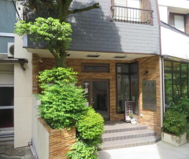 Entrance with tiled steps, glass doors and greenery at Hakone Miyanoshita Myojokan in Kanagawa, Japan