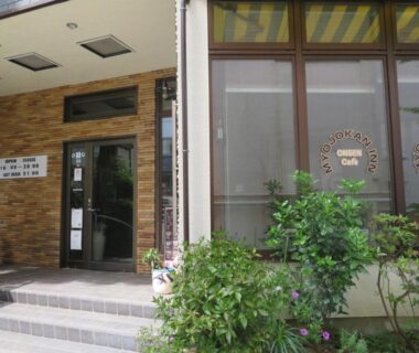 Entrance with tiled steps, glass doors, brick facade and greenery at Hakone Miyanoshita Myojokan Kanagawa
