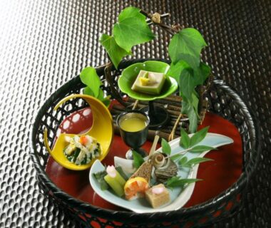 Tray of assorted small Japanese dishes in woven basket at Yaeikan ryokan, Hakone, Kanagawa, Japan