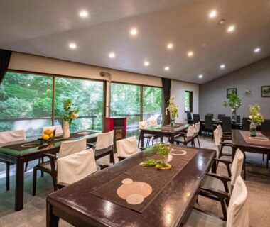 Communal dining room with wooden tables and garden view at Hakone Onsen Sanso Nakamura, Kanagawa