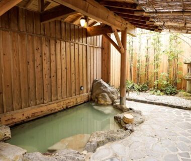 Stone onsen bath with wooden fence and stone paving at Hakone Onsen Yuyado Yamanoshou Kanagawa